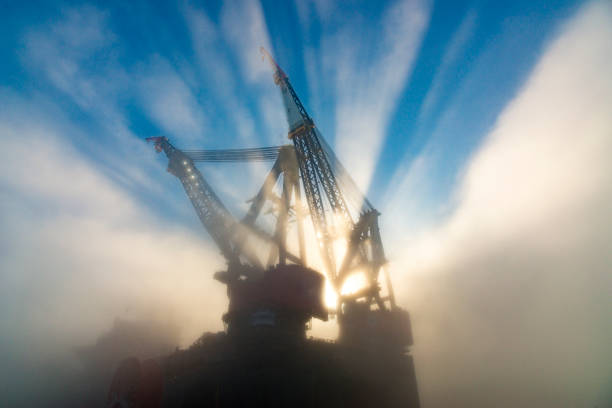 Offshore oil platform in the early morning fog, low angle view.