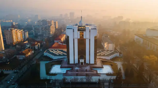 The Presidency building at sunrise in Chisinau, Moldova. Fog in the air, bare trees, buildings, roads. View from the drone