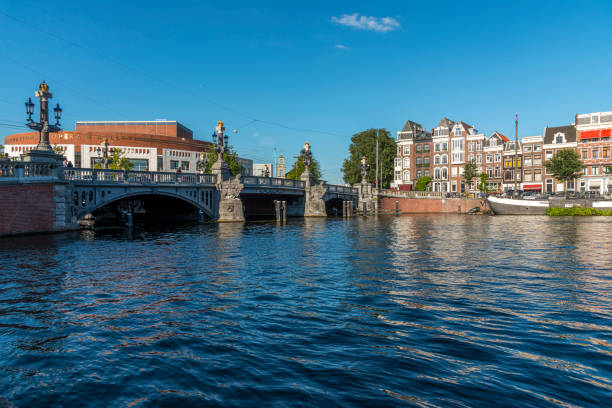 il ponte blauwbrug (azzurro) sul fiume amstel di amsterdam. - amstel river foto e immagini stock