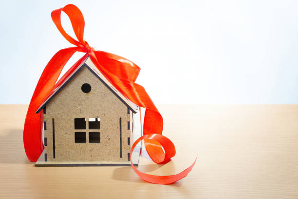 istock Miniature house wrapped with a red ribbon 1365555446