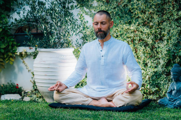 istock Peaceful Man Meditating, Sitting in Lotus Position. 1365555490