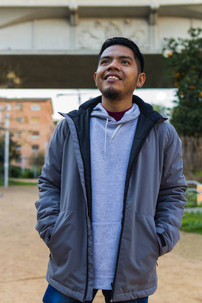 istock Young man native from mexico with hands in pockets standing in a public park 1365555594