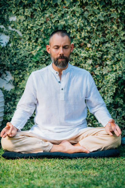 istock Peaceful Man Meditating, Sitting in Lotus Position. 1365555734