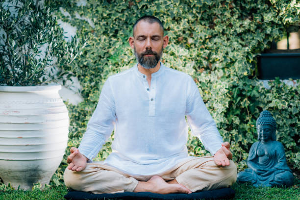 istock Peaceful Man Meditating, Sitting in Lotus Position. 1365555821