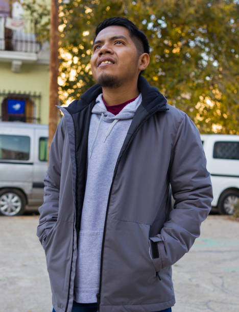 istock Central American guy standing in a town square while looking up 1365557913