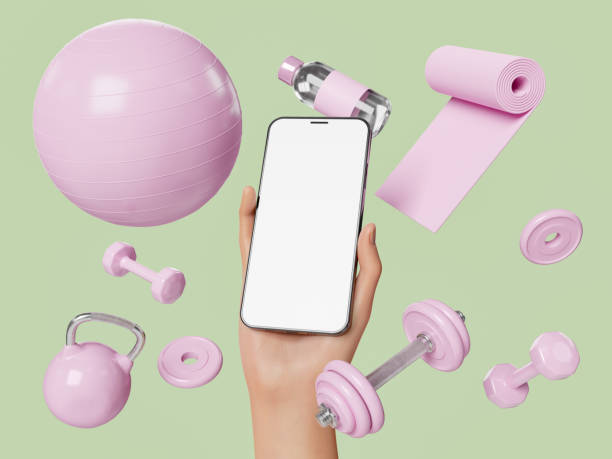 рука, держащая мобильный телефон со спортивным инвентарем вокруг него - exercise equipment exercising dieting sport стоковые фото и изображения