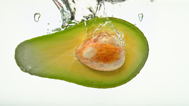 SLO MO LD Half an avocado falling into water