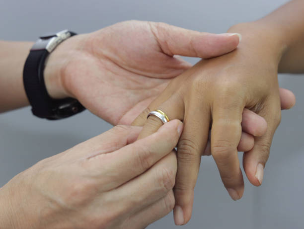 istock Close up of Holding Hands with wedding rings on the ceremony image 1365559613