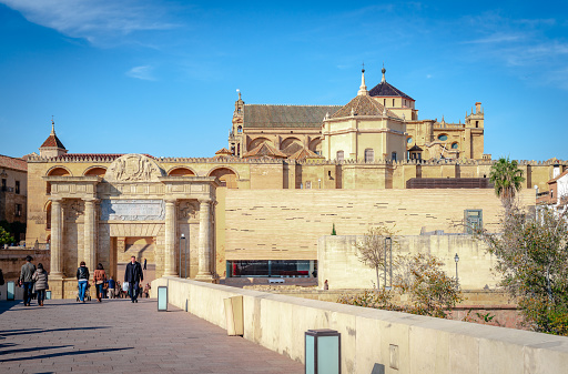 Córdoba, Spain - December 24 2014: Puerta del Puente (Gate of the Bridge) and Mosque-Cathedral of Córdoba, seen from the Roman Bridge.