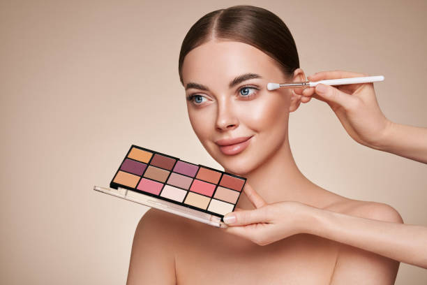 istock Makeup artist applies eye shadow 1365562285