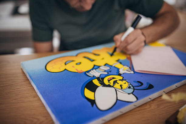 One man, male artist coloring his painting at the table at home workshop.