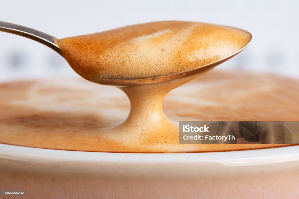 Cup latte coffee with spoon of foam Macro view, cup latte coffee with spoon of foam Crema - Coffee Stock Photo