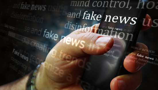 Titles on screen in hand with fake news and hoax information 3d illustration