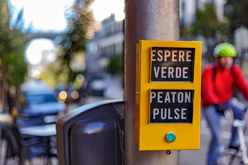 Madrid, Spain.  December 3 2021. Wait sign for pedestrians in Madrid. Semaphore box. Push buttom. Cyclist in background. Segovia street