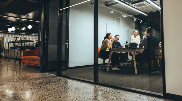 colegas de negocios que tienen una reunión en una sala de juntas - trabajo en equipo fotografías e imágenes de stock