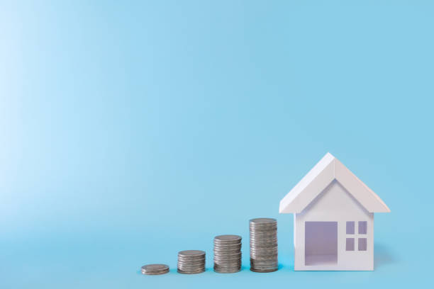 istock white house model with coins stack in blue background for money management,  refinance plan and real estate concept. 1365570877