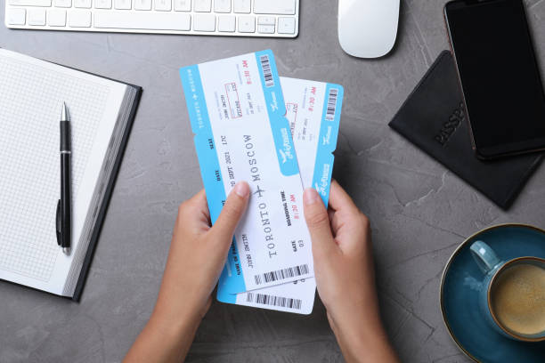 Woman with airline tickets at grey table, top view. Travel agency concept Woman with airline tickets at grey table, top view. Travel agency concept airplane ticket stock pictures, royalty-free photos & images