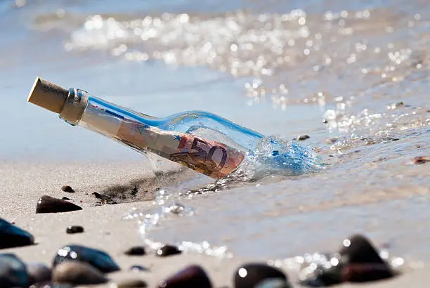 message in a bottle on the beach fullly with euronotes