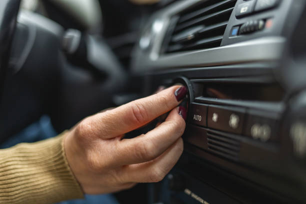 istock Woman adjusting interior temperature while driving on the road 1365576325