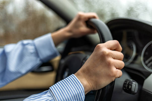 Young man on a driving seat with both hands on the wheel, sign of a safe driver.