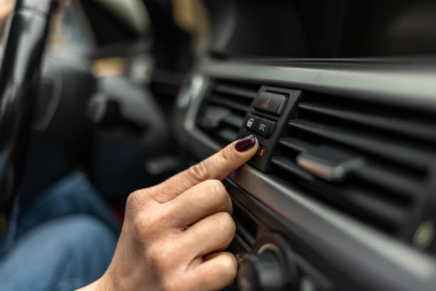 la conductora está ajustando el aire acondicionado del automóvil - car dashboard air conditioner driving fotografías e imágenes de stock