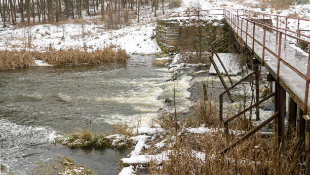 istock An old footbridge over a small river. First snow in the countryside. 1365579297