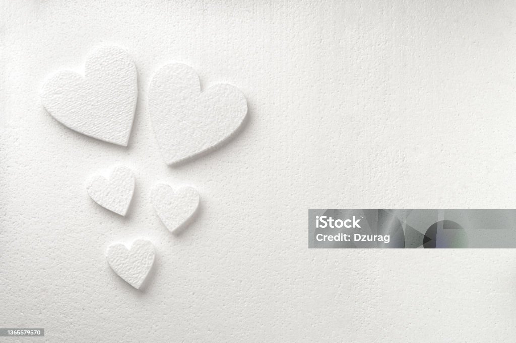 Background with white styrfoam hearts on the sheet of a white styrfoam Background with white styrfoam hearts on the sheet of a white styrfoam with a copy space. Valentine's day background Polystyrene Stock Photo