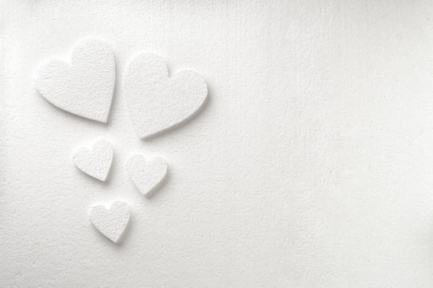 Background with white styrfoam hearts on the sheet of a white styrfoam stock photo