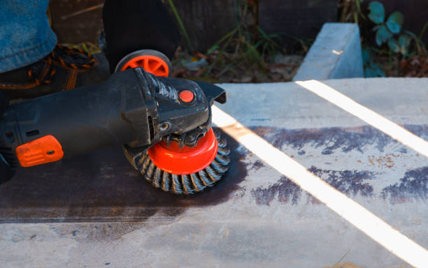 istock Hand with a turbine removes rust from metal. man using angle grinder 1365580322