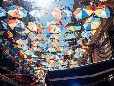 Catania, Italy - August 31, 2021: street covered with many umbrellas in Catania, Sicily. Street with many colorful umbrellas.