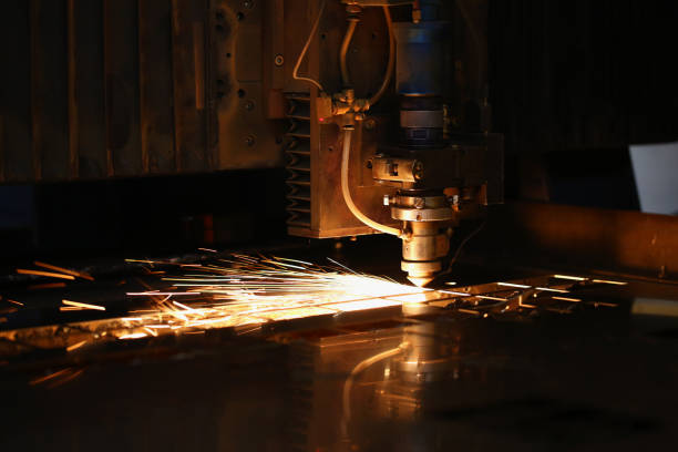 las chispas salen volando de la máquina automatizada, el láser de procesamiento de metales en el fondo metalúrgico - cutting plate fotografías e imágenes de stock