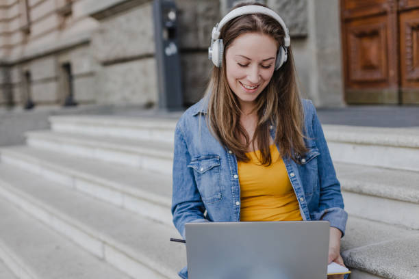 istock Young woman using laptop in front of the University 1365584818