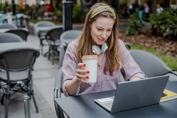 istock Young woman is using laptop in coffee shop 1365586128