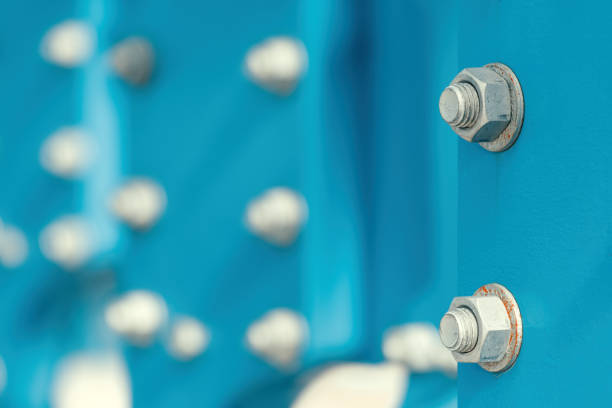 Large industrial screws nuts and bolt fastening machinery steel plates, selective focus
