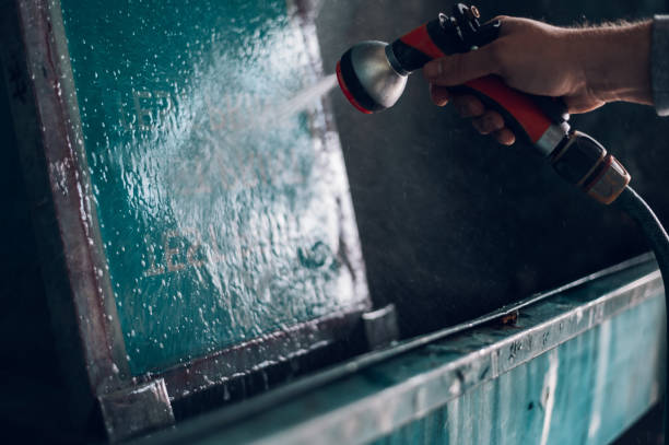 istock Male worker cleaning screen frame with water in a printing workshop 1365590320