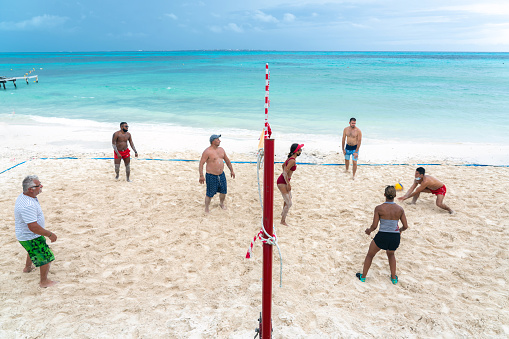 Cancun, Mexico - September 11, 2021: Tourists playing volleyball on a beach in all inclusive hotel in Cancun, Mexico.
