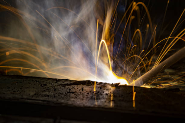 istock Macro of welding in progress, with bright light trails from flying sparks 1365595559