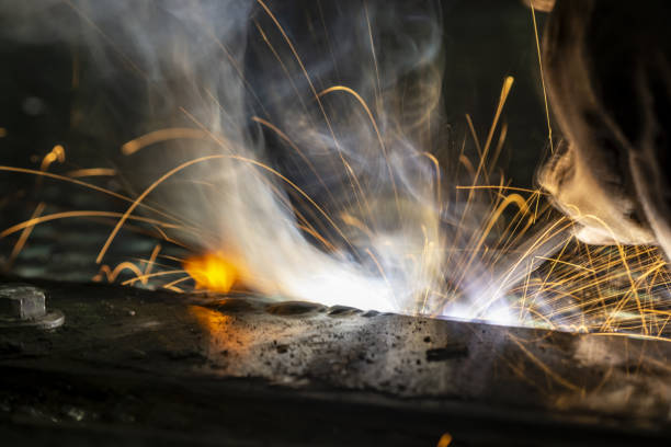 istock Macro of stick welding, with bright light and flame starting as sparks fly 1365597154