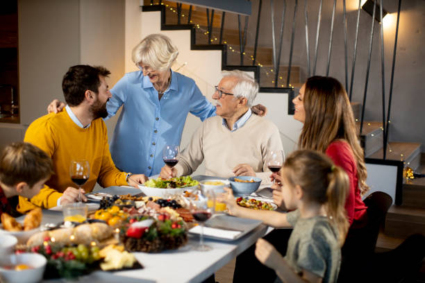 istock Happy family having dinner with red wine at home 1365597216