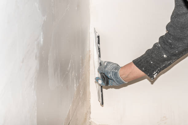 le mani di un lavoratore livellano le pareti con una spatola usando stucco durante le riparazioni. - plaster putty cement decorating foto e immagini stock