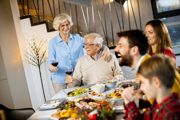 istock Happy family having dinner with red wine at home 1365598538