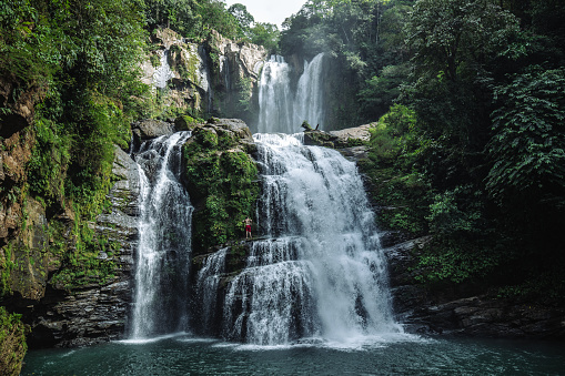 tourist trekking to waterfall in tropical forest during holiday. Holiday activities.