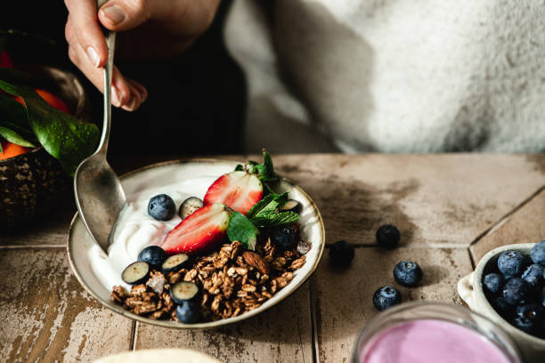 健康的な朝食を食べる女性のクローズアップ - ギリシャヨーグルト ストックフォトと画像
