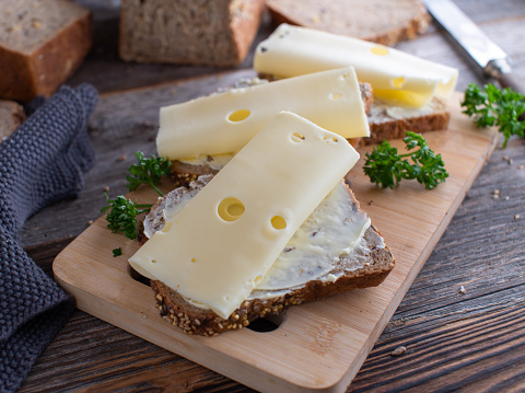 Traditional german Brotzeit with a buttered cheese sandwich. Served on wooden table background