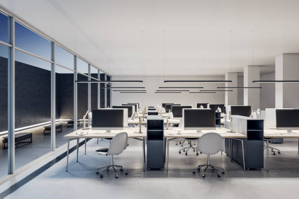 istock Modern coworking office interior with empty computer monitors on wooden desks, equipment, furniture and panoramic windows. 3D Rendering. 1365601468