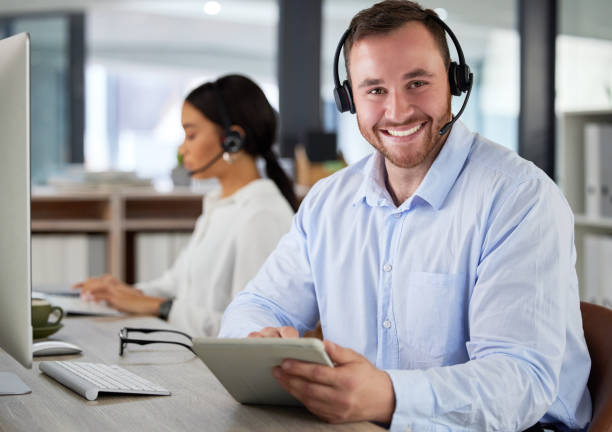 istock Shot of a young man using a headset and digital tablet in a modern office 1365601666