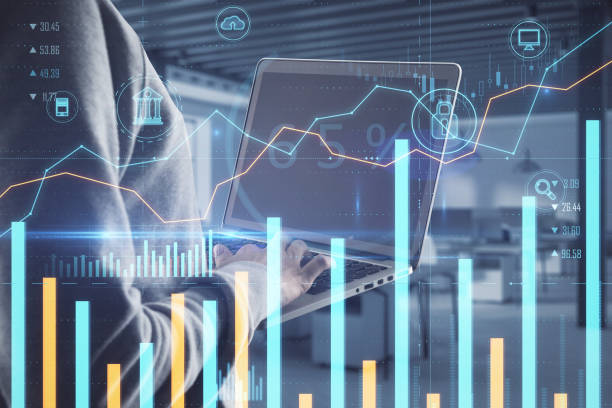 Hacker using laptop with creative glowing business chart on blurry office background. Online banking, safety, hacking and finance concept. Double exposure. stock photo