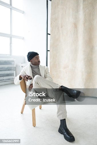 istock Elegant young man wearing white winter coat 1365602991