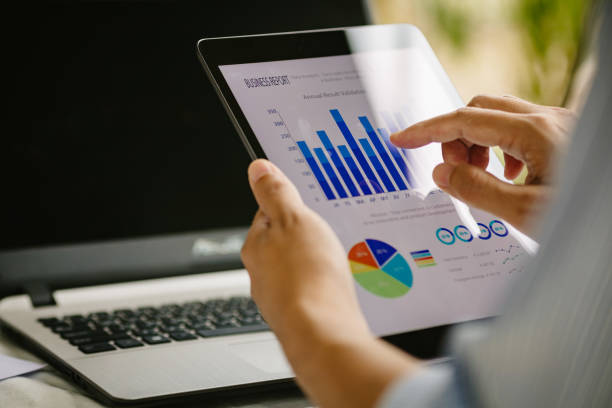 istock businessman working on project for analyzing company financial statistic result with smart device at modern office space. Concept for business, economy and tax. 1365603559