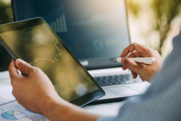 istock businessman working on project for analyzing company financial report balance statement with documents graphics at modern office space. Concept picture of business,economy, market,money and tax. 1365603649